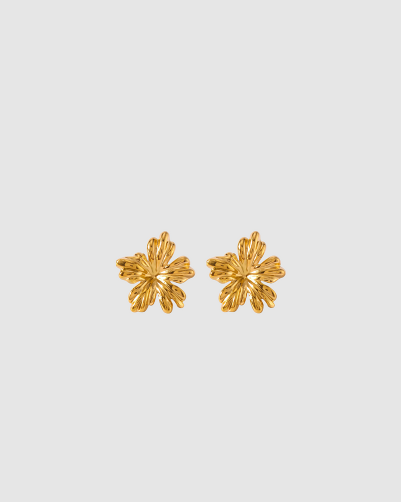 A pair of gold-colored floral design stud earrings on a white background